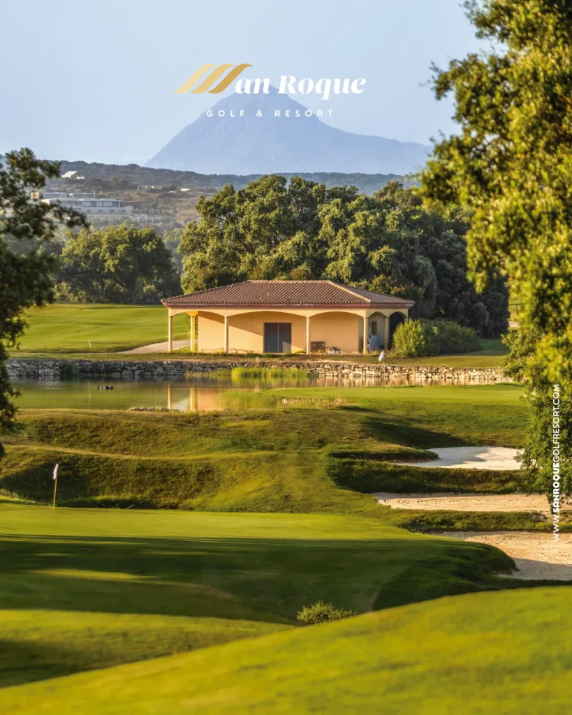 Campo de golf en San Roque con el Peñón al fondo, un lago y el green rodeado de alcornoques
